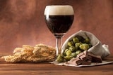 bruin bier in een glas, graan en hop